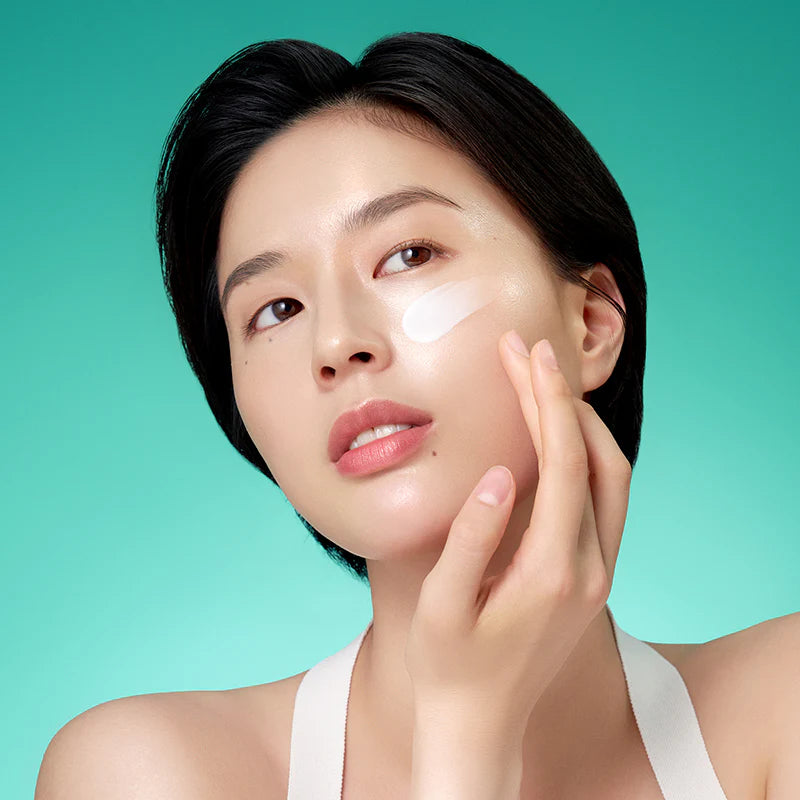 Vrouw brengt de PURITO Mighty Bamboo Panthenol Cream aan op haar wang