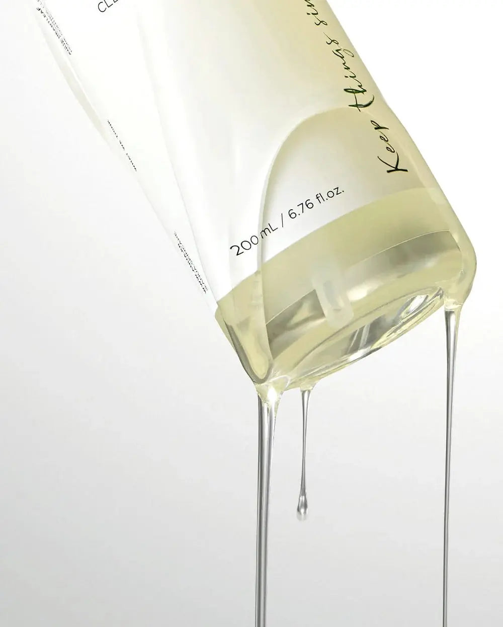 Anua Heartleaf Pore Control Cleansing Oil, heldere olie druipt uit de omgekeerde flacon