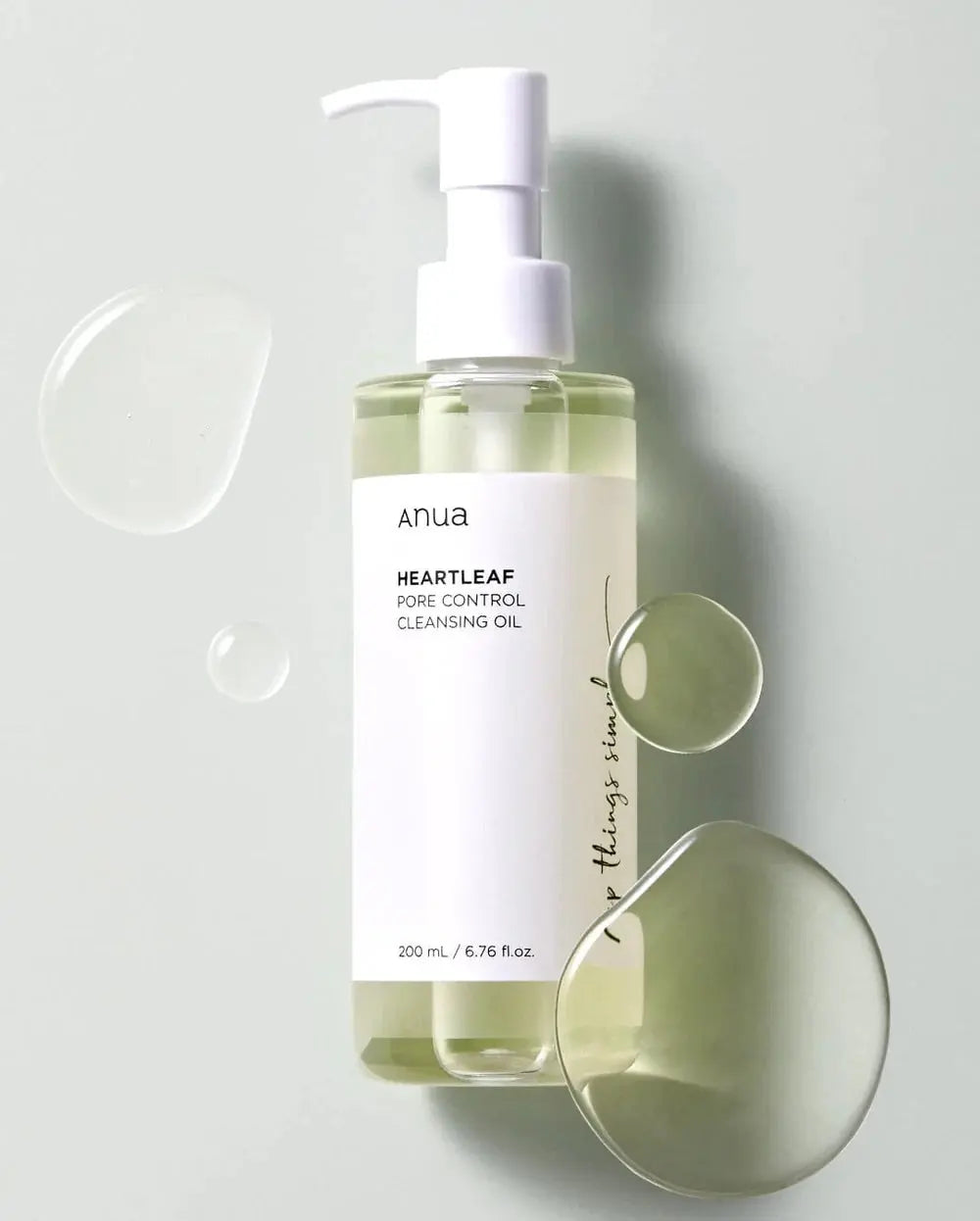 Anua Heartleaf Pore Control Cleansing Oil, flacon met druppels olie op een lichte achtergrond