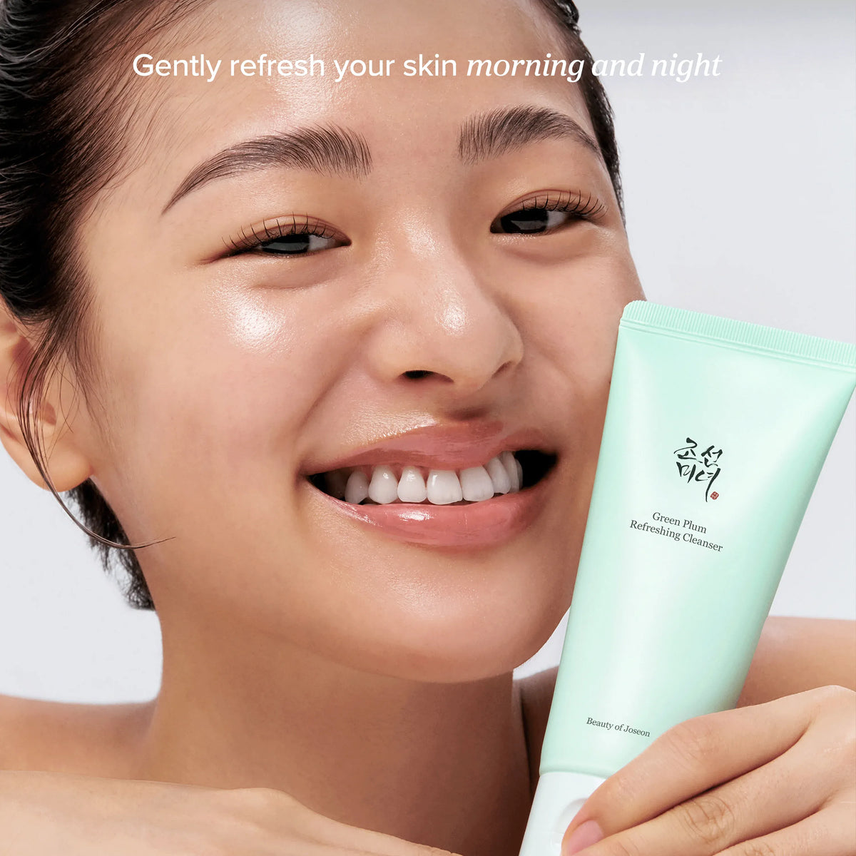 Model met de tube Beauty of Joseon Green Plum Refreshing Cleanser, verfrist de huid 's ochtends en 's avonds