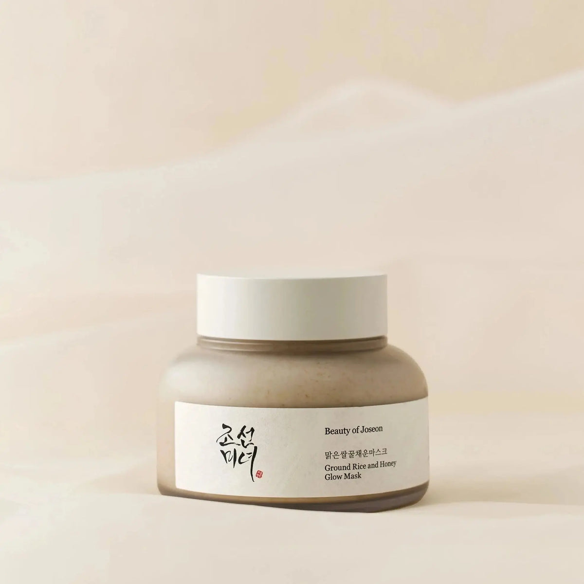 Beauty of Joseon Ground Rice and Honey Glow Mask, pot op zachte beige stof