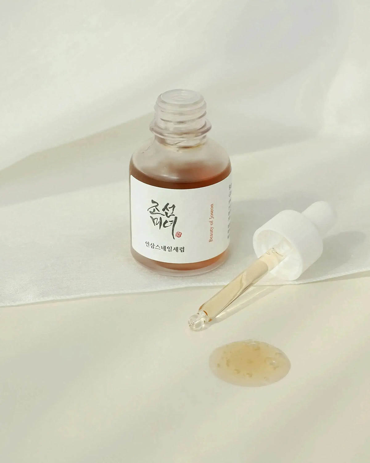 Beauty of Joseon Revive Serum: Ginseng + Snail Mucin, geopende flacon met pipet en een druppel serum