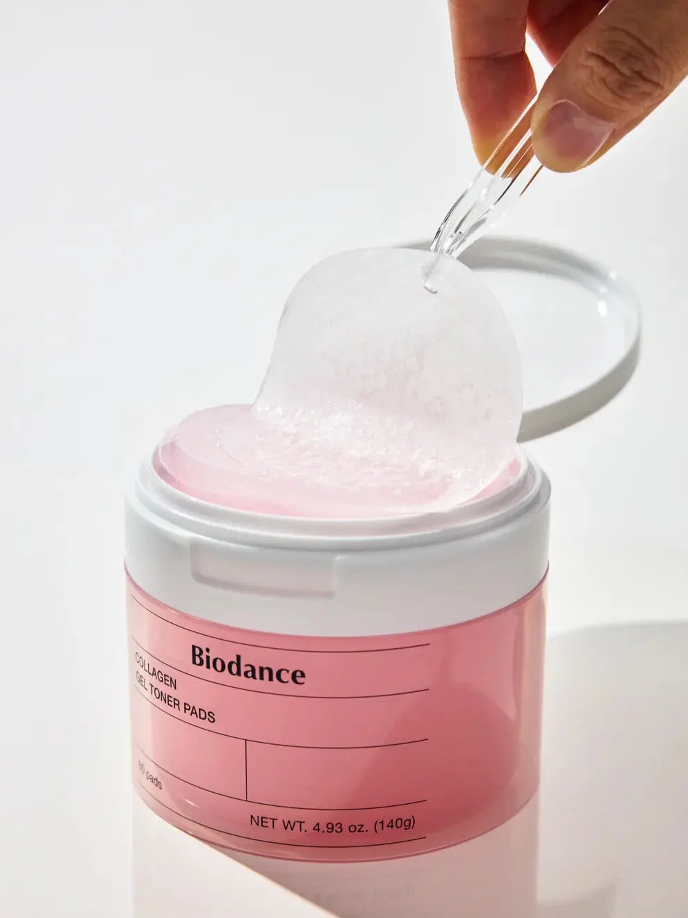 Biodance Collagen Gel Toner Pads, pincet tilt een doorzichtige gelpad uit de pot