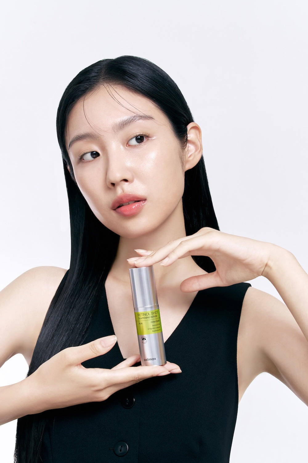 Model houdt het flesje Celimax Vita A Retinol Shot Tightening Serum omhoog