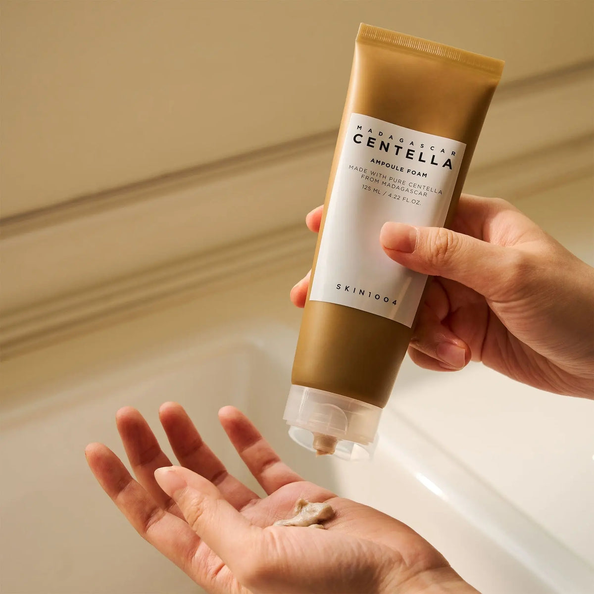 Hand knijpt SKIN1004 Centella Ampoule Foam in de handpalm