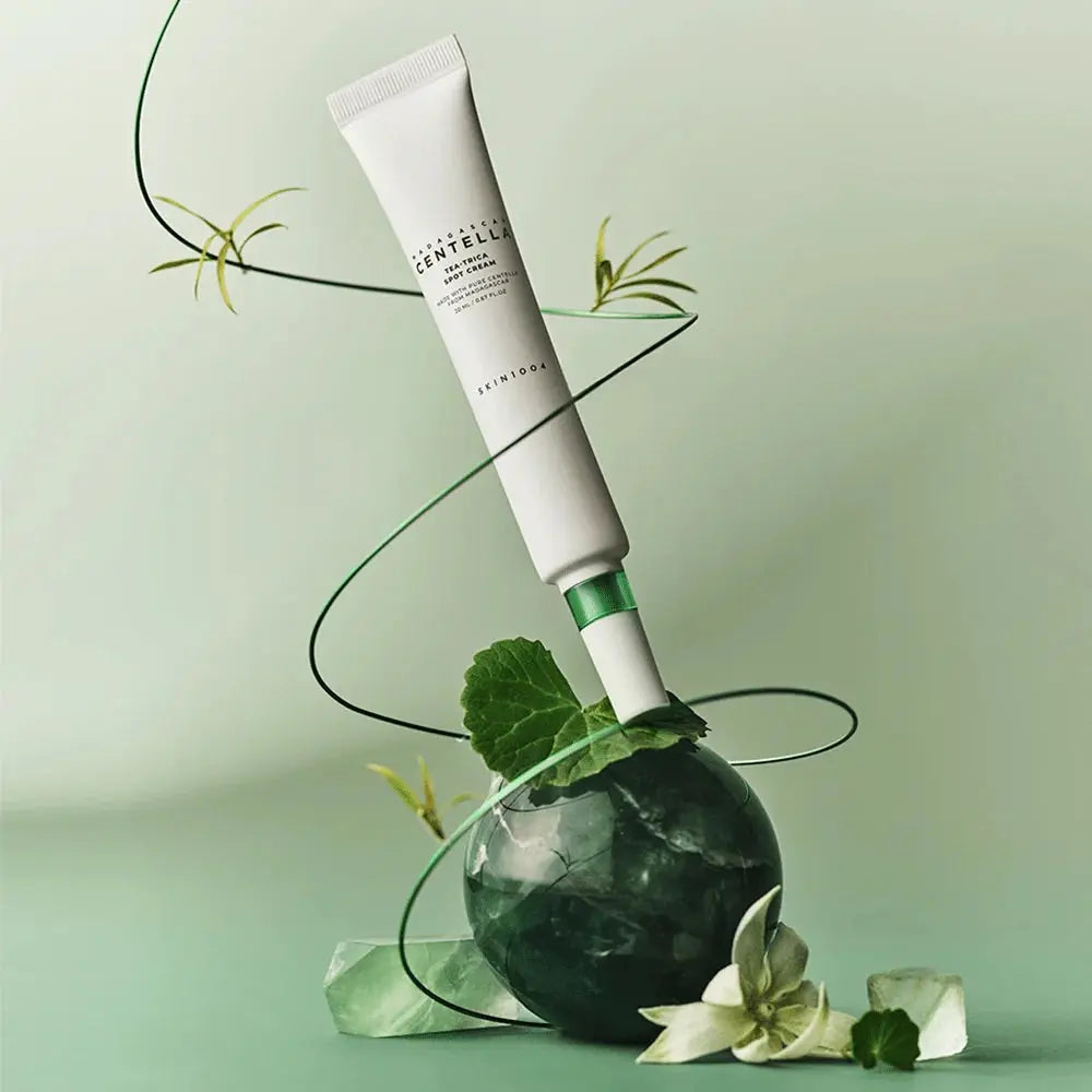 SKIN1004 Tea-Trica Spot Cream op een groene steen met takjes en blaadjes