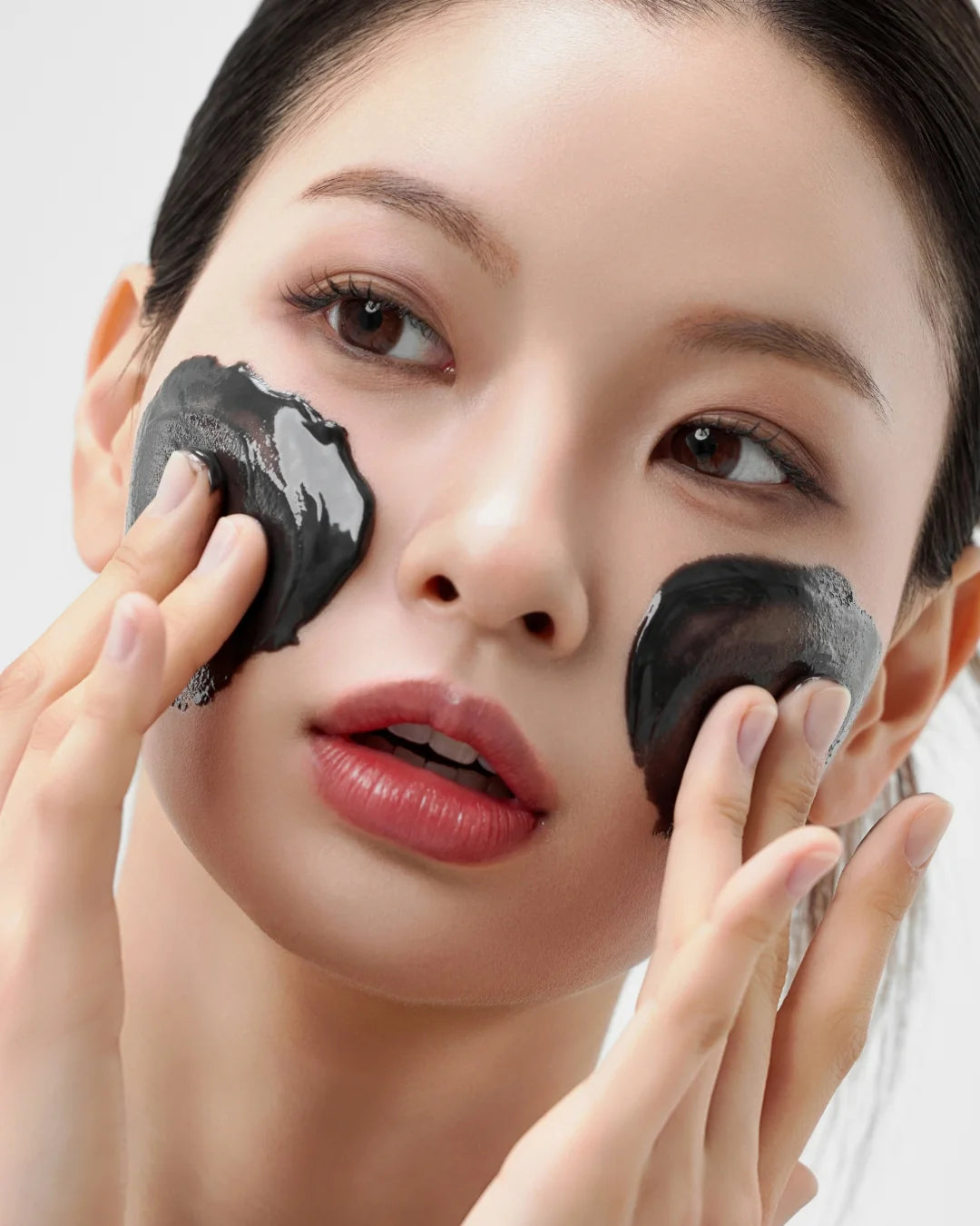 Vrouw brengt de House of Hur Midnight Soothing Cleansing Balm aan op haar wangen