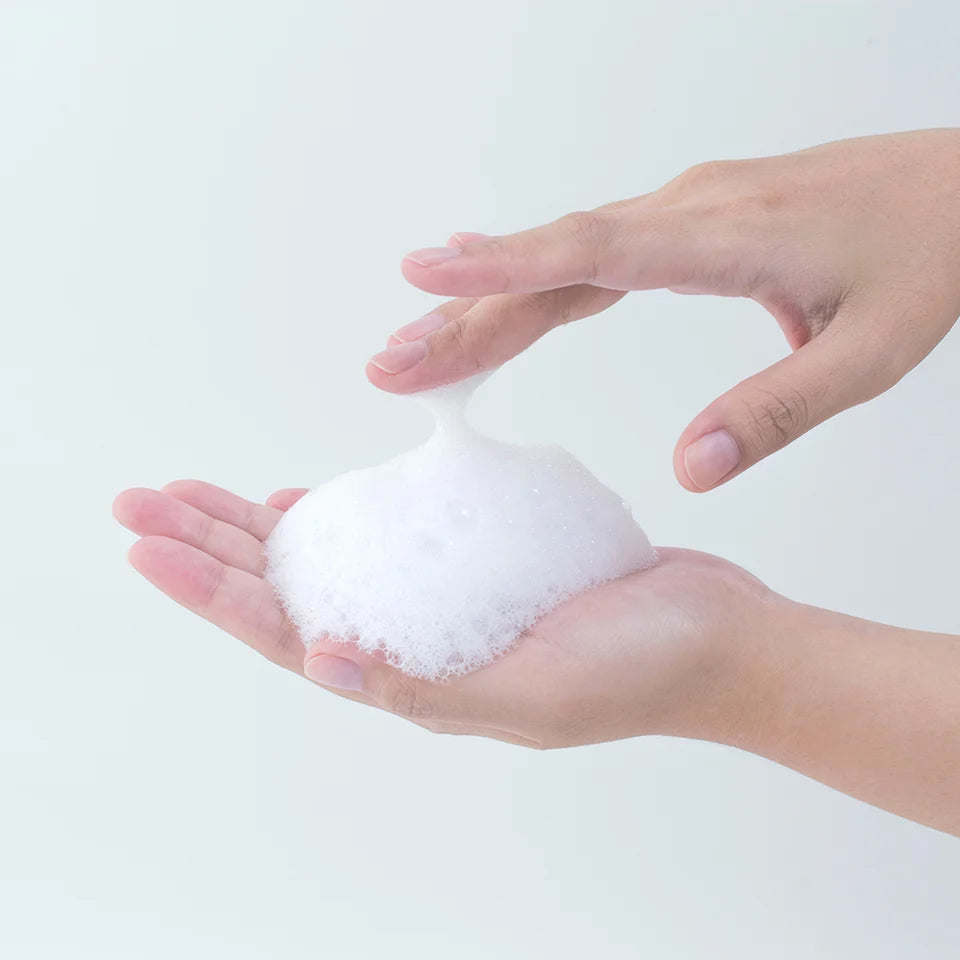 Romig, zacht schuim van Pyunkang Yul Calming Acne Cleansing Foam in de handen