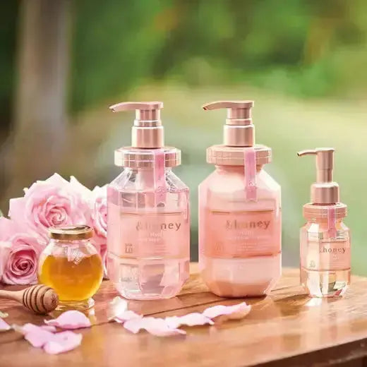 &honey Melty Moist Repair lijn met shampoo, treatment en haarolie naast rozen en honing