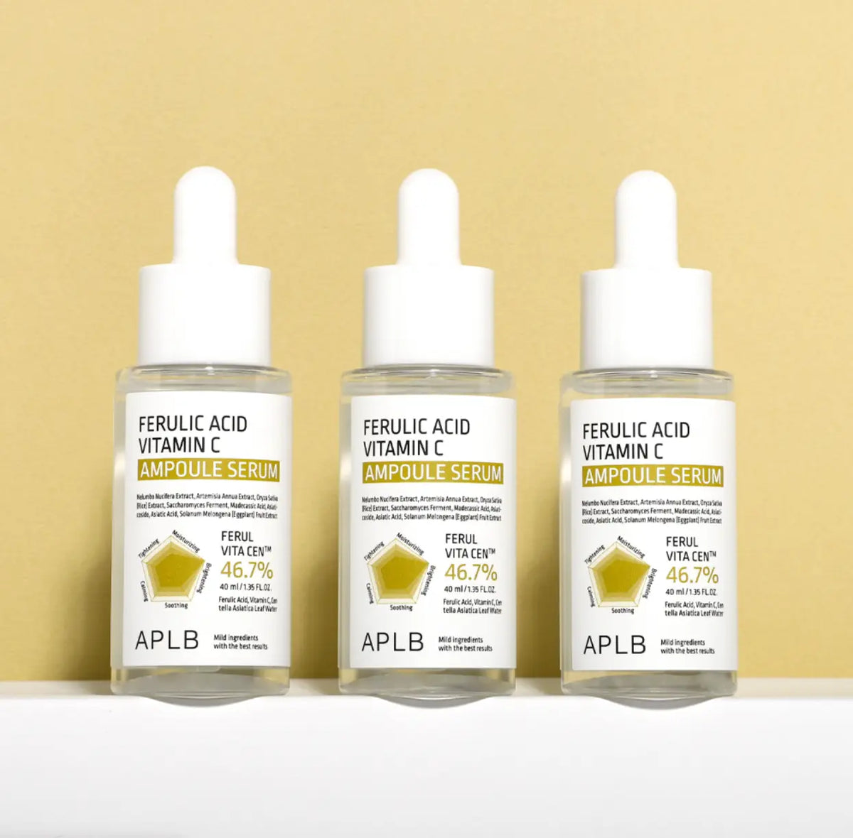 APLB Ferulic Acid Vitamin C Ampoule Serum, drie flacons op een gele achtergrond