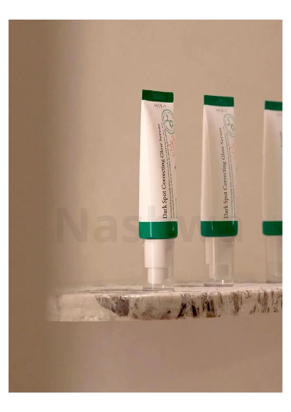AXIS-Y Dark Spot Correcting Glow Serum, tubes op een stenen plank