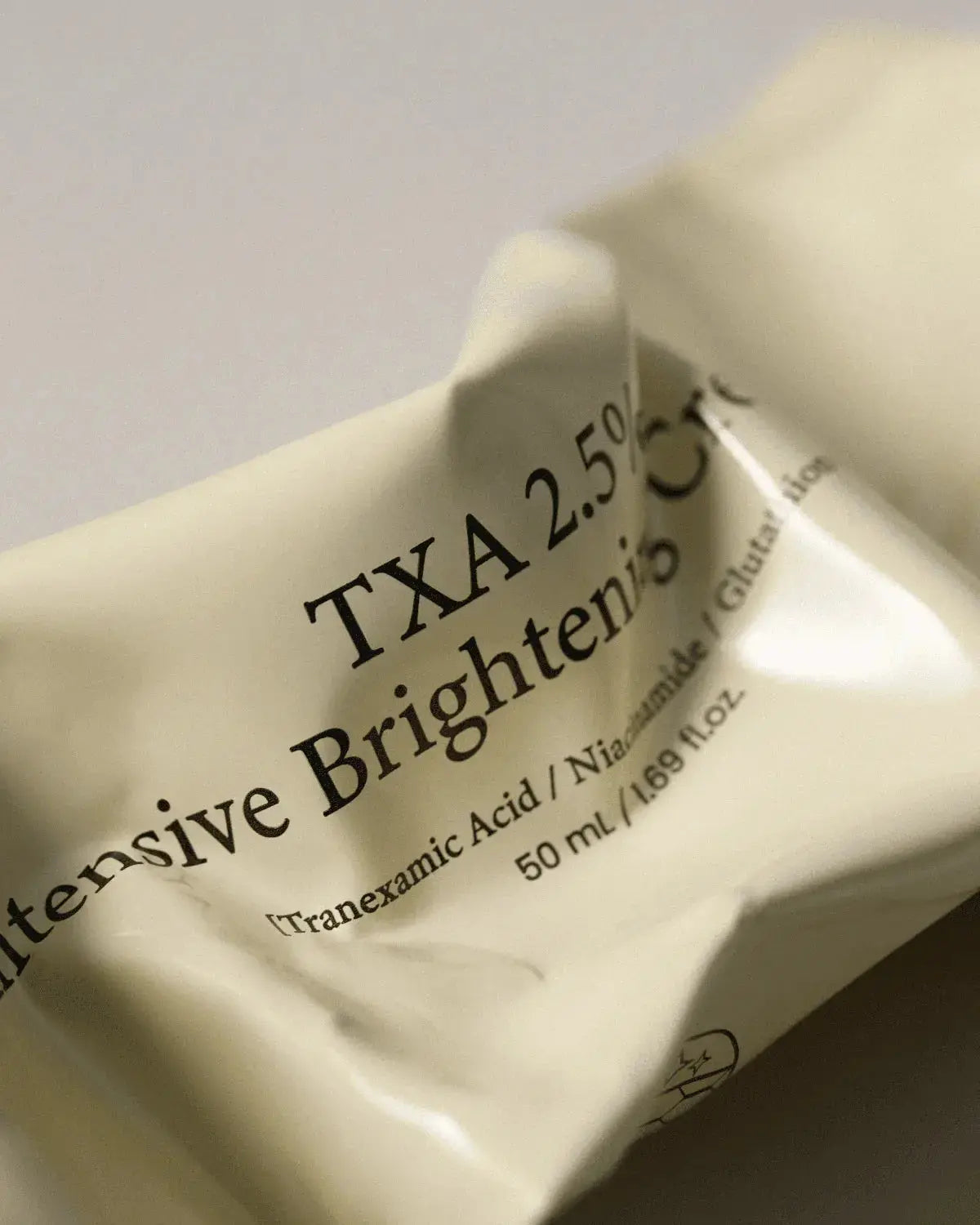 AXIS-Y TXA 2.5% Intensive Brightening Cream met tranexaminezuur en niacinamide, close-up van de tube