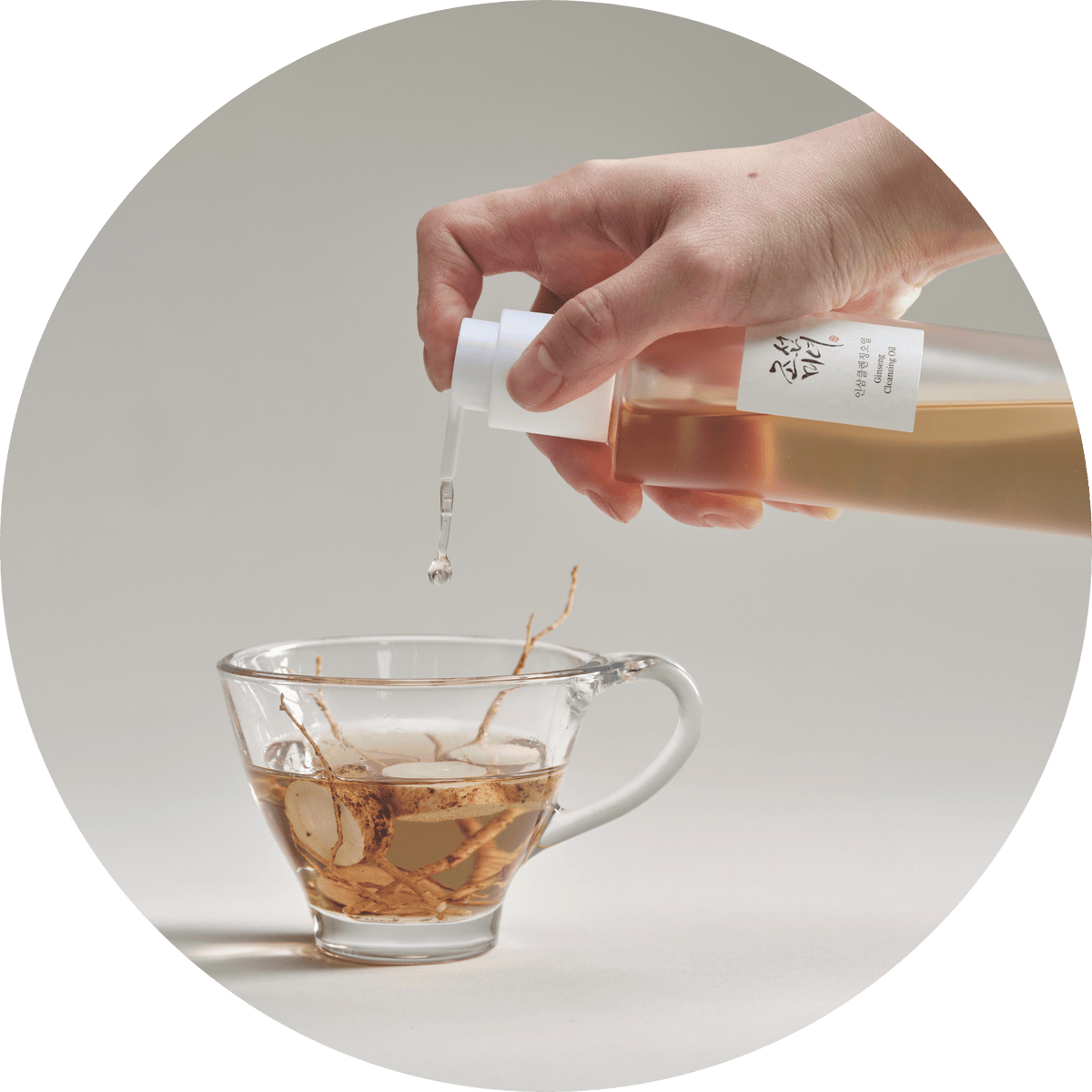 Pomp van Beauty of Joseon Ginseng Cleansing Oil boven een glazen kopje met olie