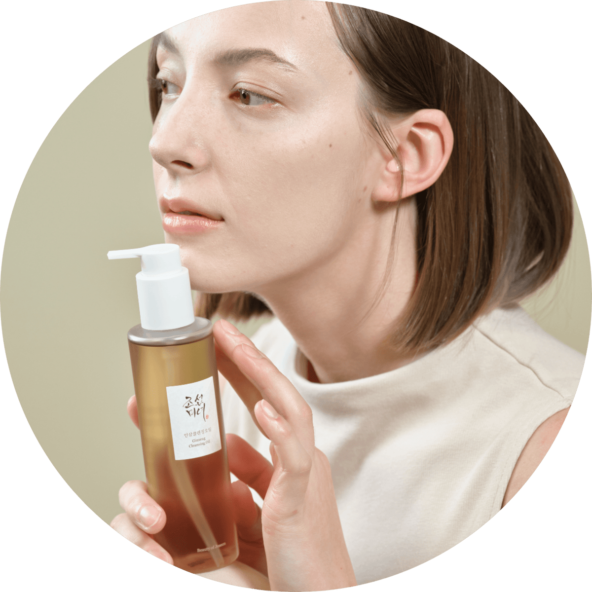 Vrouw met de flacon Beauty of Joseon Ginseng Cleansing Oil bij haar gezicht