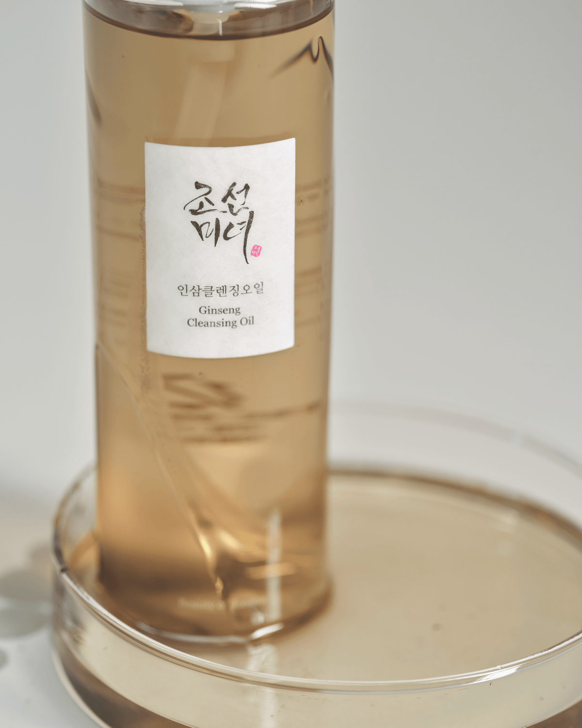 Beauty of Joseon Ginseng Cleansing Oil staat in een schaaltje met goudkleurige reinigingsolie