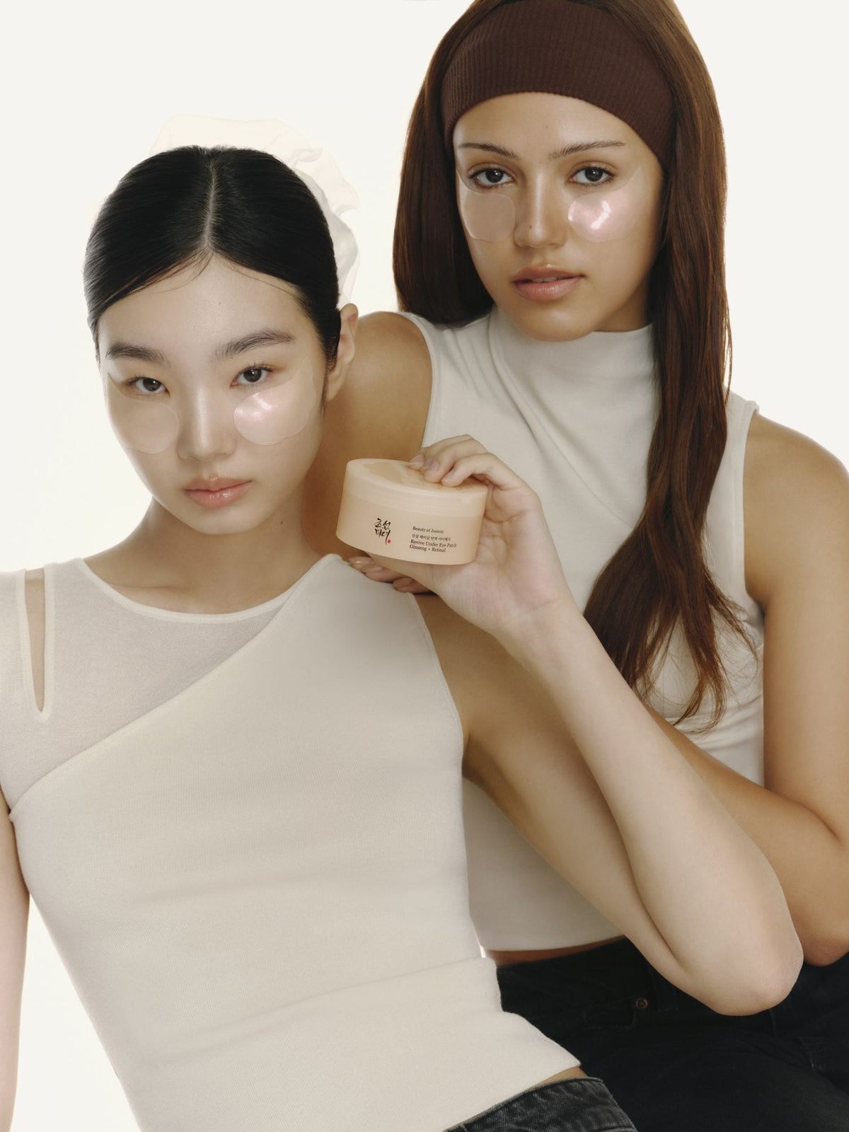 Twee modellen met Beauty of Joseon Revive Under Eye Patches en de pot