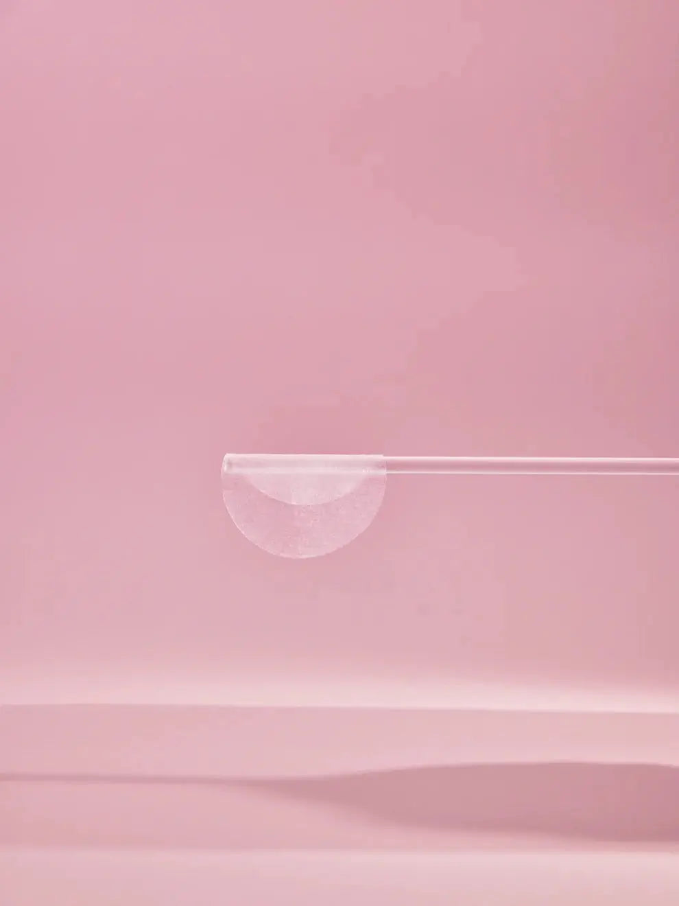 Biodance Collagen Gel Toner Pads, gelpad op een pincet tegen roze