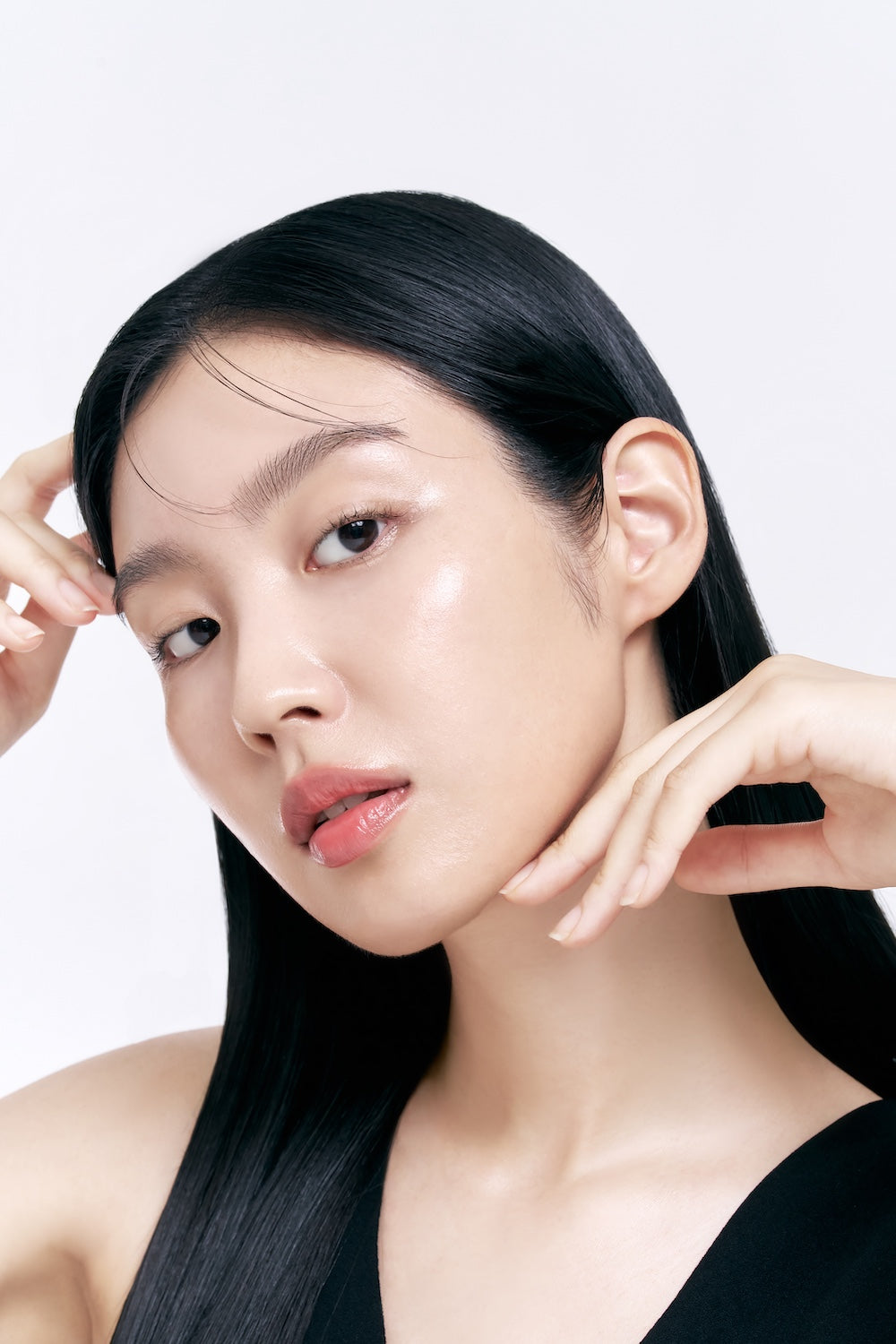 Model raakt haar wang aan, met het Celimax Retinol Shot Serum in beeld