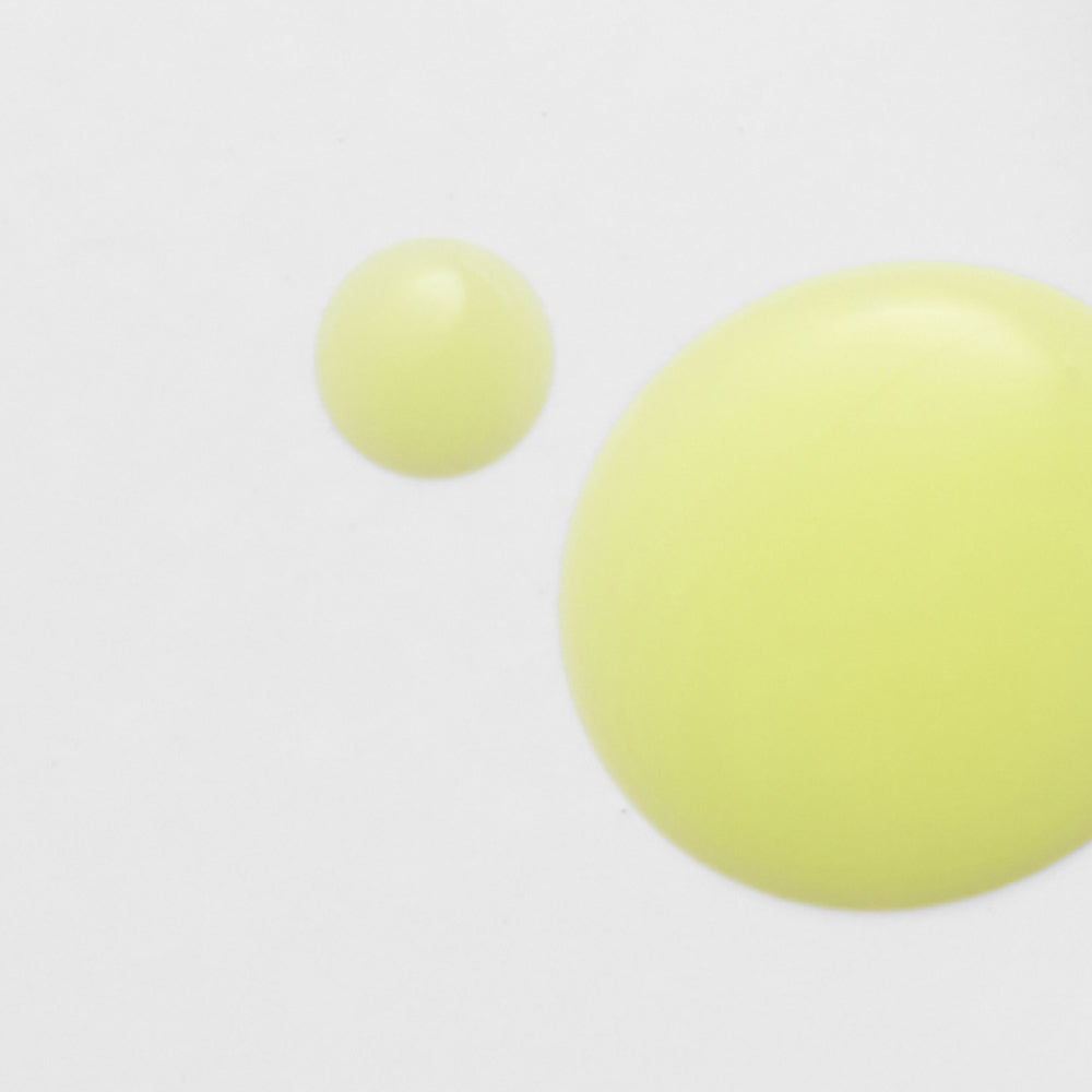 Twee gele druppels die de lichte serumtextuur van het Celimax Retinol Shot Serum laten zien