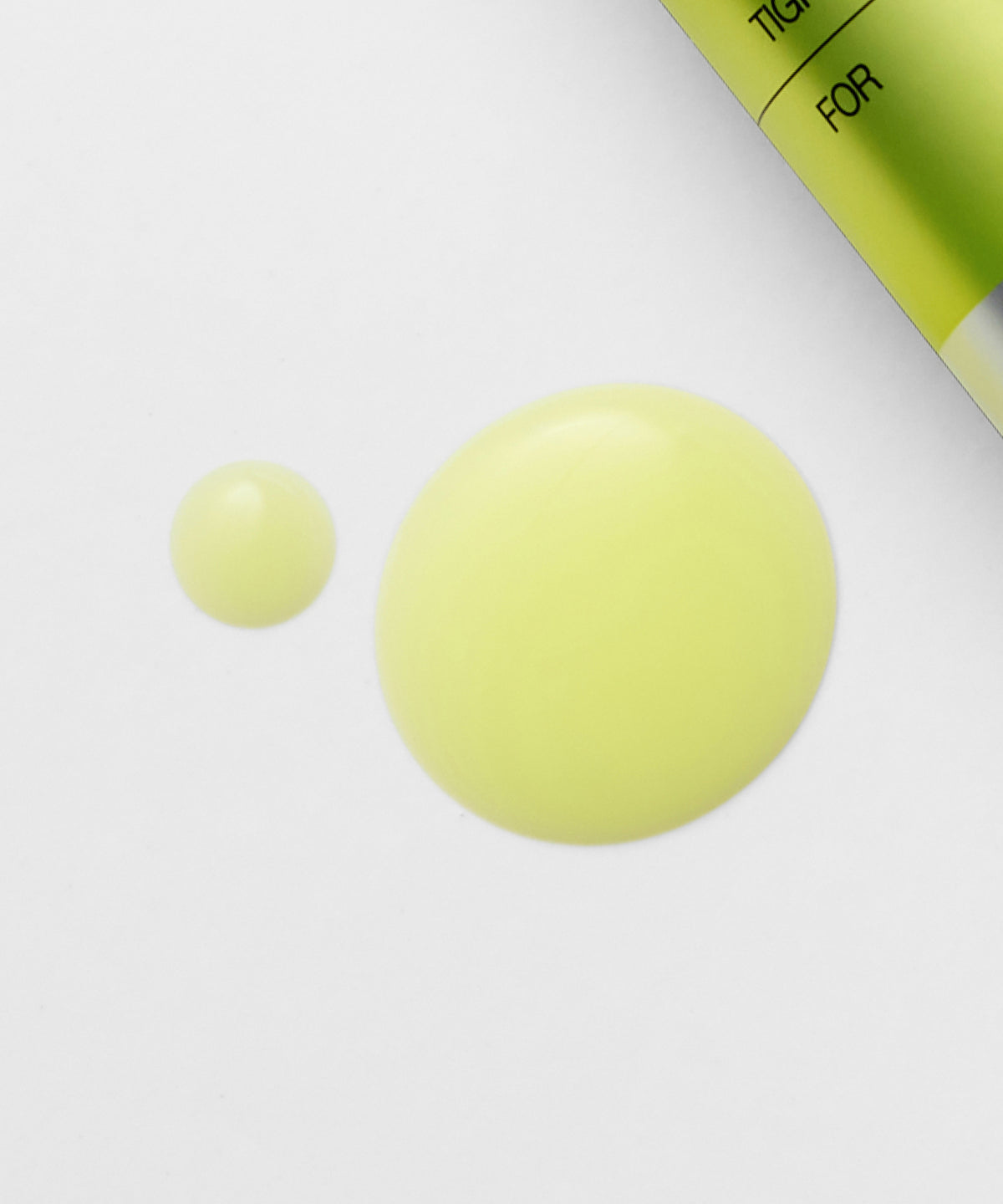 Gele serumdruppels naast de verpakking, die de textuur van het Celimax retinol serum tonen