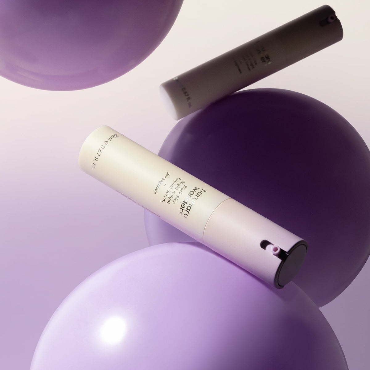 Twee flesjes Haruharu Night Knight Retinol Serum tussen paarse bollen