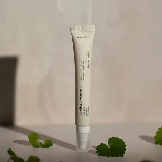 Haruharu Wonder Black Rice Bakuchiol Eye Cream, tube tussen groene blaadjes