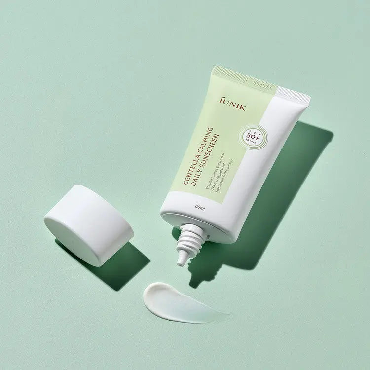iUNIK Centella Calming Daily Sunscreen, geopende tube met een veeg zonnebrand