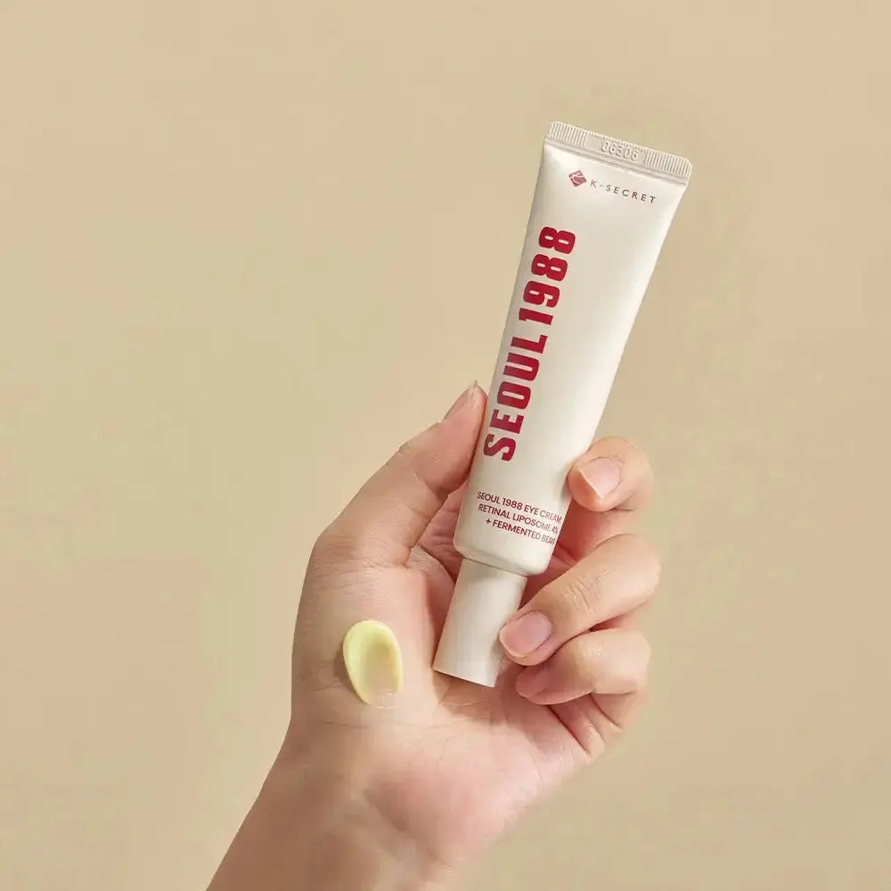 K-SECRET SEOUL 1988 Eye Cream: Retinal Liposome 4% + Fermented Bean, hand houdt de tube met een klodder crème