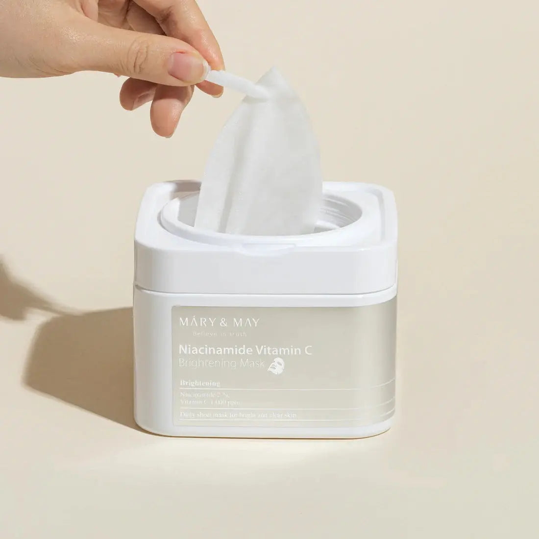 Mary & May Niacinamide Vitamin C Brightening Mask, hand trekt een masker uit de pot