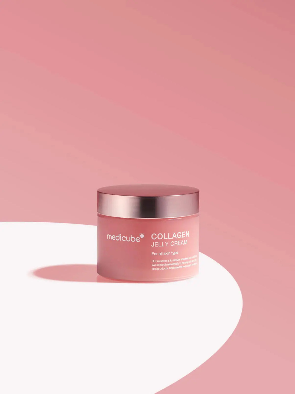 Medicube Collagen Jelly Cream, pot op een witte rand tegen een roze achtergrond
