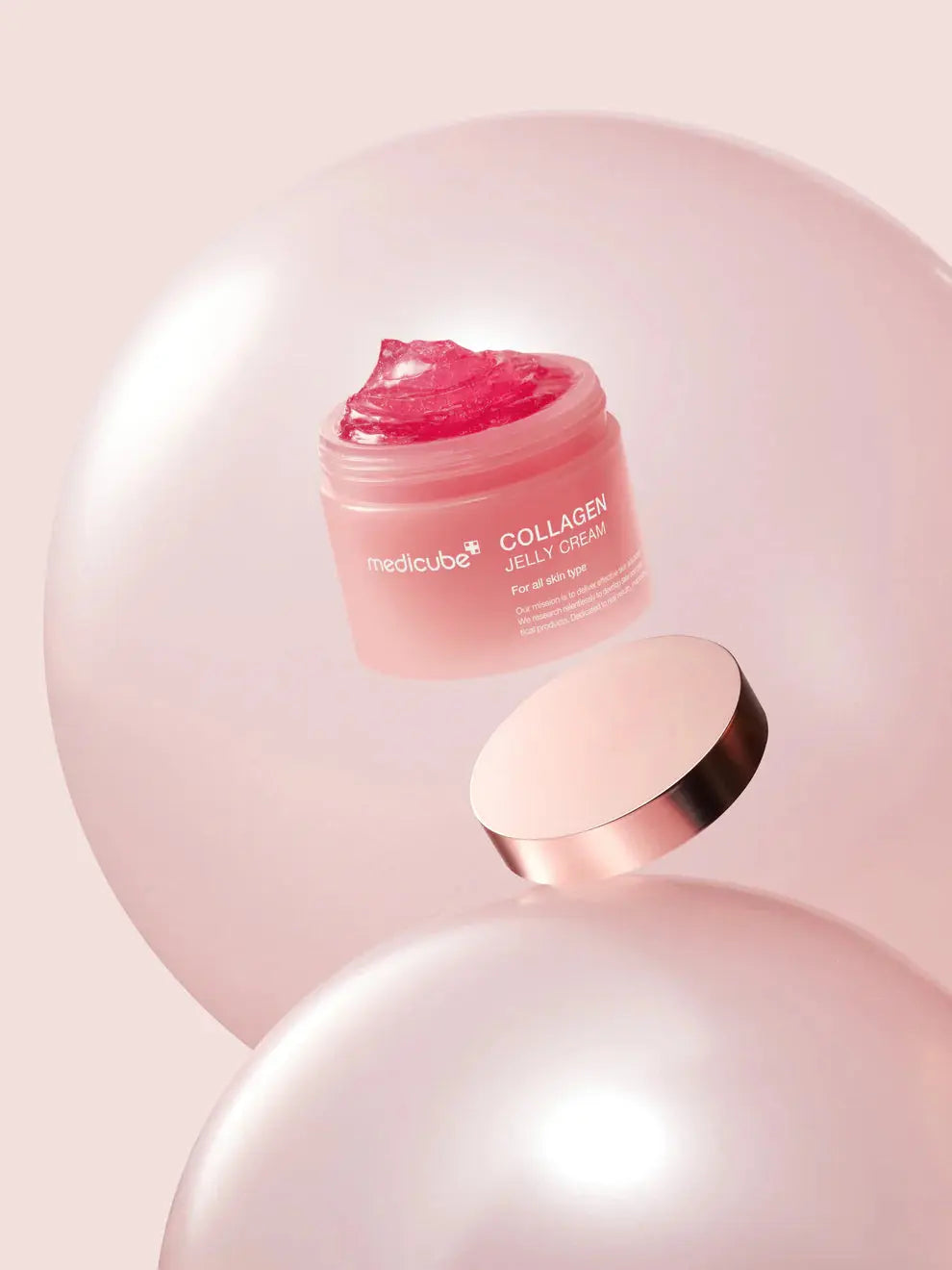 Medicube Collagen Jelly Cream, zwevende geopende pot met deksel tussen parelachtige bollen