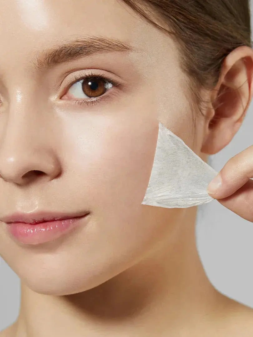 Medicube Collagen Night Wrapping Mask, vrouw trekt het opgedroogde masker van de wang