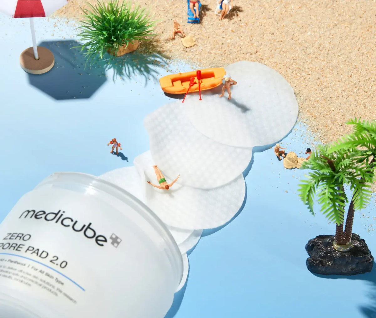 Medicube Zero Pore Pad 2.0, losse pads naast de pot met miniatuurfiguurtjes op het strand