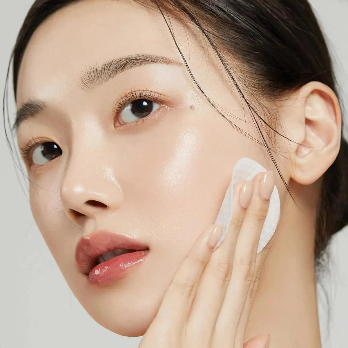 Medicube Zero Pore Pad Mild, vrouw veegt een pad over de wang