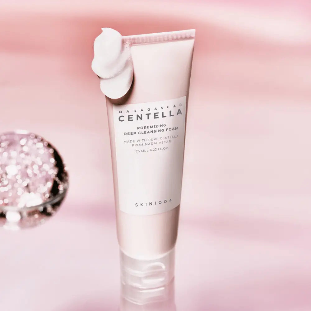 SKIN1004 Poremizing Deep Cleansing Foam met schuim op de dop tegen een roze achtergrond