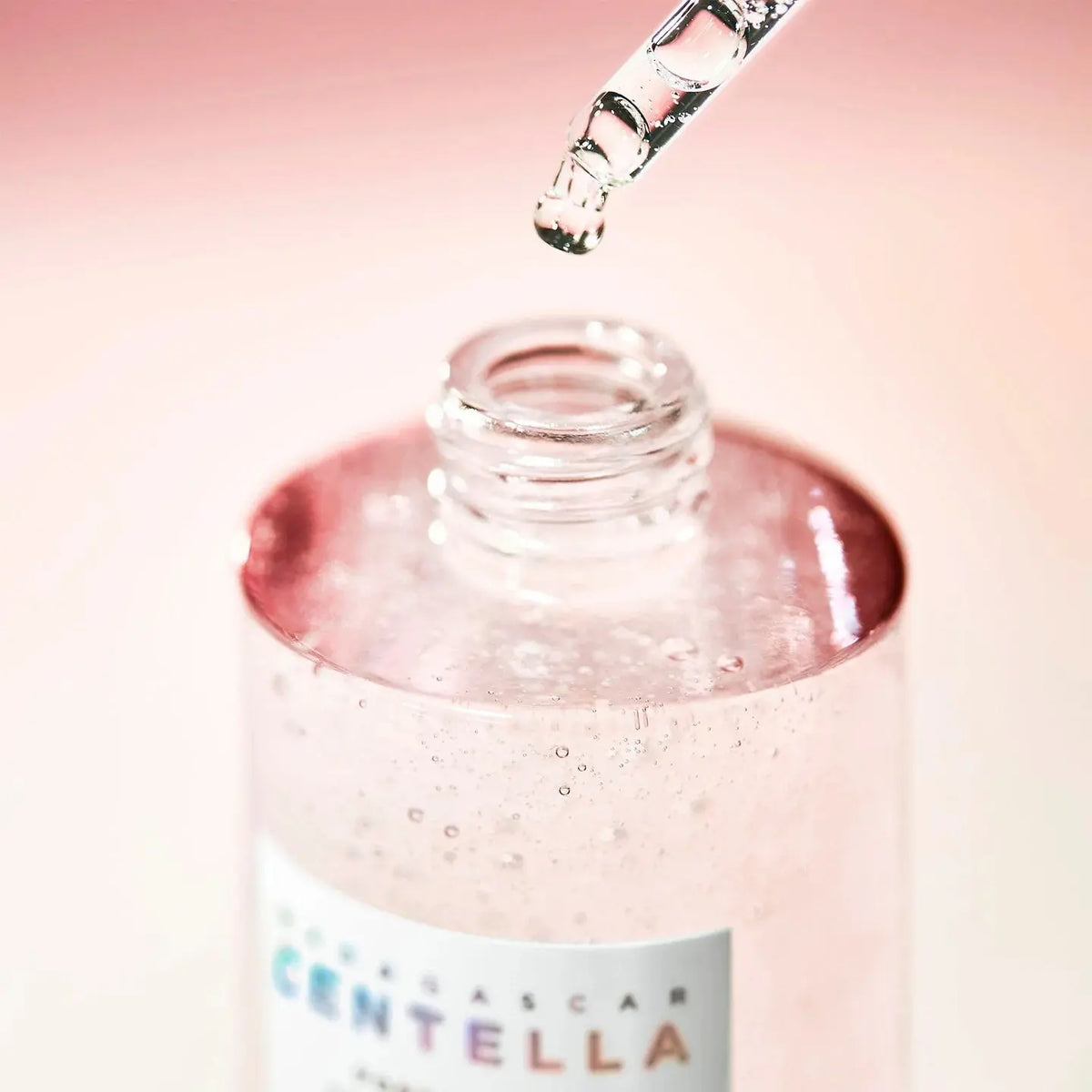 Pipet boven de open fles SKIN1004 Poremizing Fresh Ampoule met roze glinstering