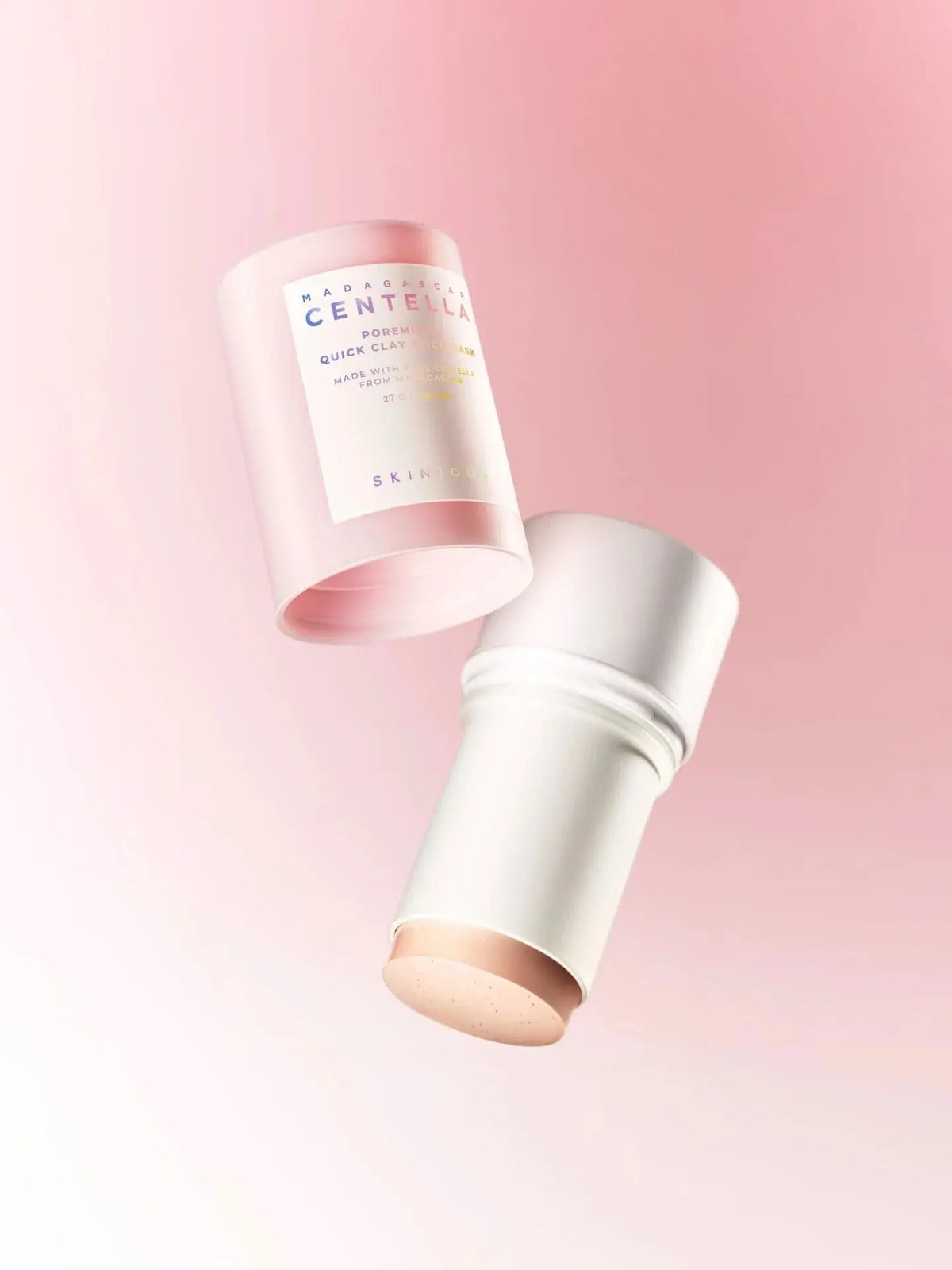 Dop en stick van de SKIN1004 Poremizing Quick Clay Stick Mask zwevend tegen roze