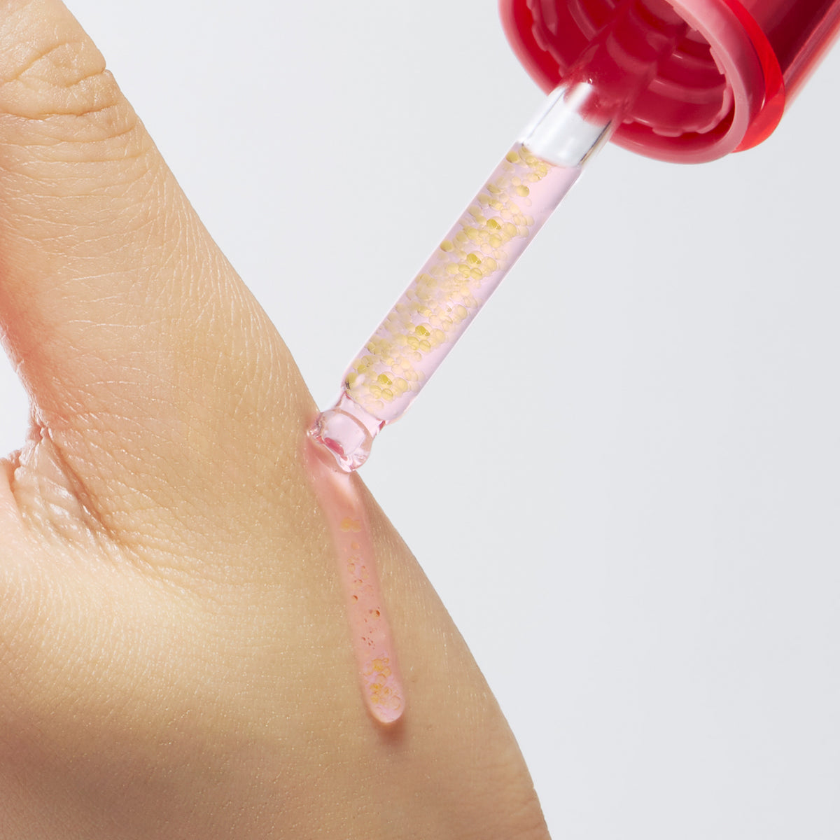 Pipet van het PURITO TXA 6 Niacinamide 10 Retinal Serum druppelt serum op de hand