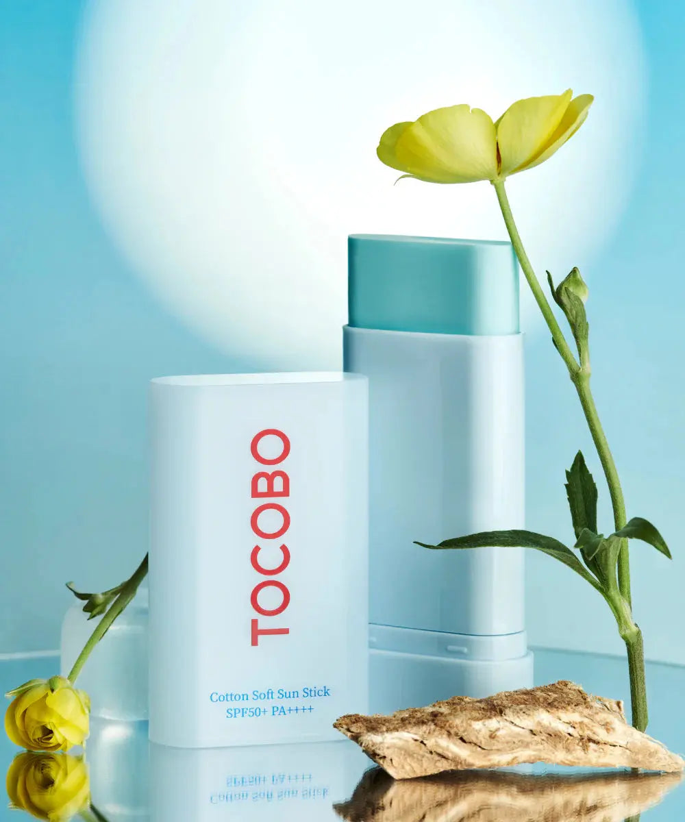 TOCOBO Cotton Soft Sun Stick SPF50+ PA++++, sticks tussen gele bloemen